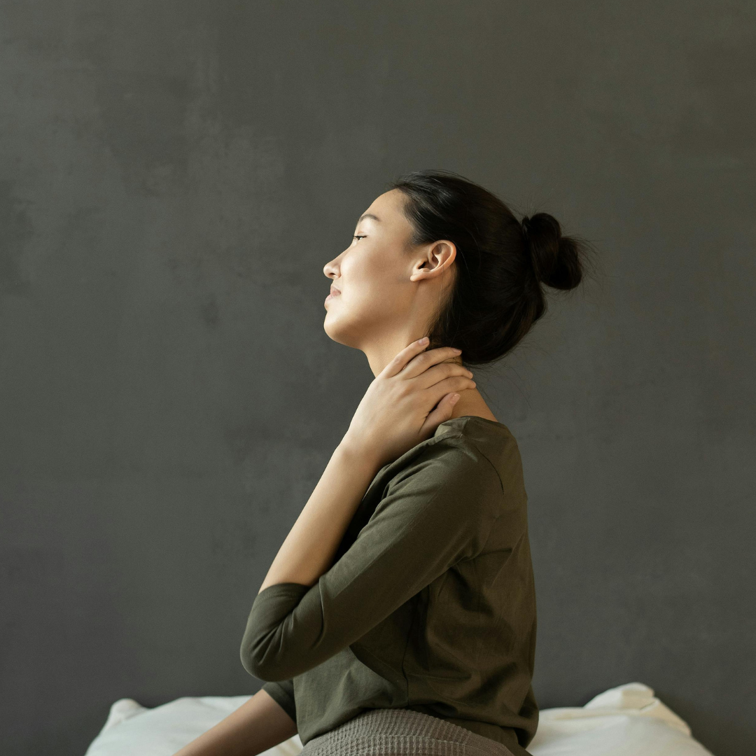Woman rubs her neck to ease the discomfort of fibromyalgia.